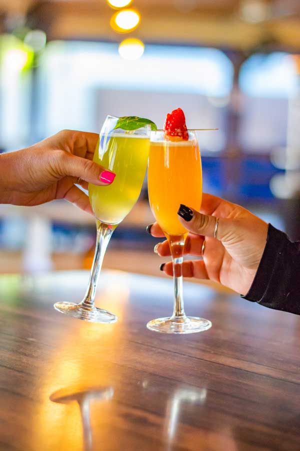 Two People Cheer-sing Mimosas at Clermont Brewing Company