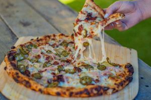 Person Tearing a Slice of Pizza Off